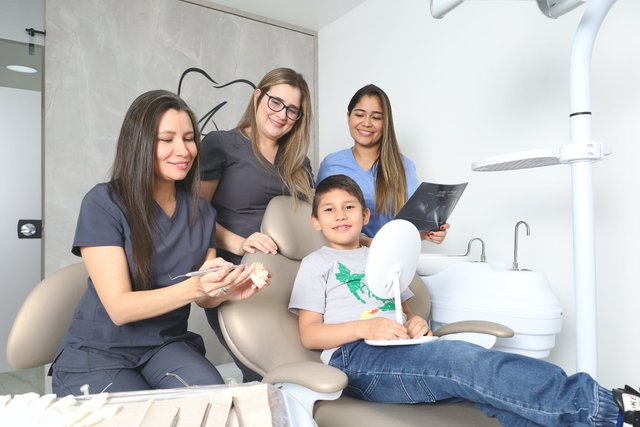 free-photo-of-smiling-women-posing-with-boy-at-dentist.jpeg