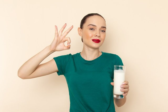 front-view-young-female-dark-green-shirt-blue-jeans-holding-milk-smiling-beige_140725-21038.jpg