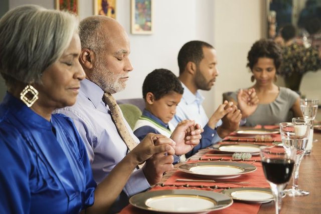 african-american-family-saying-grace-at-dining-table-98478715-5aaf94503418c60036b157b6.jpg