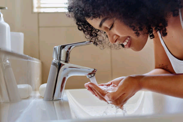 shot-of-a-beautiful-young-woman-washing-her-face-in-the-bathroom.jpg