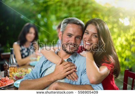 stock-photo-summertime-portrait-of-a-beautiful-couple-looking-at-the-camera-they-are-sitting-with-friends-556905409.jpg