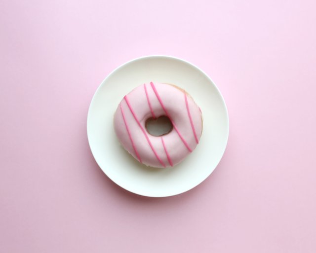 pink-iced-doughnut-on-a-white-plate-on-a-pale-pastel-pink-background_t20_Rzevem.jpg