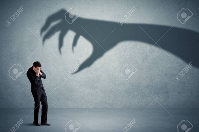 63785012-business-person-afraid-of-a-big-monster-claw-shadow-concept-on-background.jpg