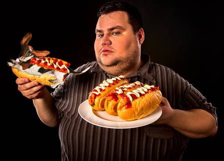 76186181-gros-homme-mangeant-fast-food-hot-dog-sur-plaque-petit-déjeuner-pour-personne-en-surpoids-le-repas-ind.jpg