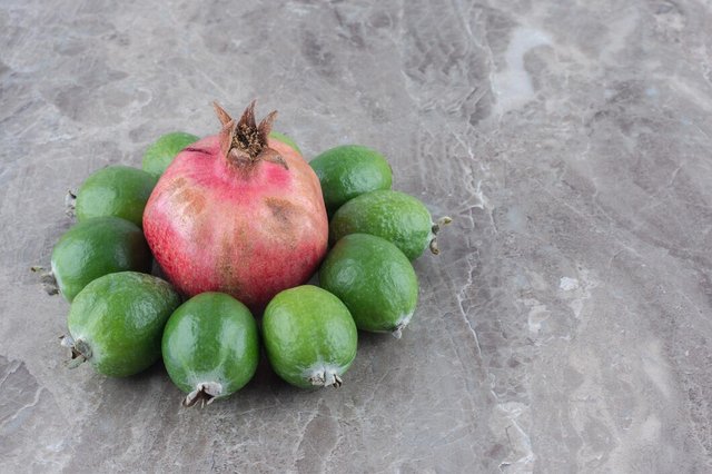 pomegranante-ringed-with-feijoas-marble-surface_114579-54868.jpg