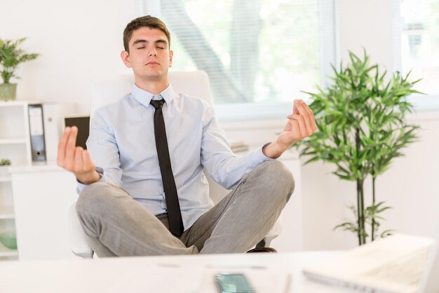 young-businessman-practicing-yoga-office-he-sits-lotus-pose-chair-front-her-desk_360066-20418.jpg