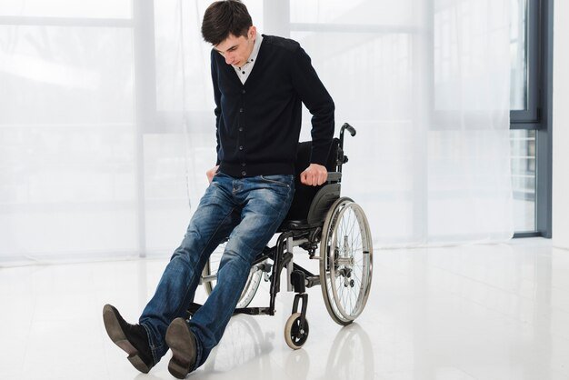 young-man-trying-get-from-wheelchair_23-2148127402.jpg