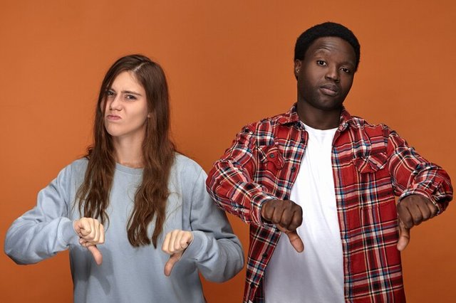 isolated-picture-dissatisfied-frowning-young-european-woman-dark-skinned-man-grimacing-making-thumbs-down-gesture-expressing-disapproval-dislike-being-disappointed-with-bad-movie_343059-1408.jpg