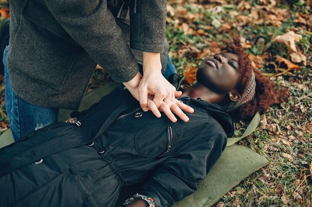 guy-help-woman-african-girl-is-lying-unconscious-providing-first-aid-park_1157-40382.jpg