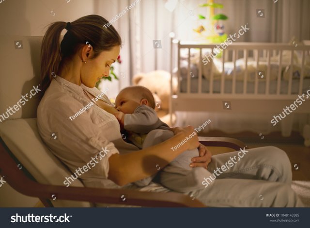 stock-photo-young-beautiful-mother-breastfeeding-her-newborn-baby-boy-at-night-dim-light-mom-breastfeeding-1048143385.jpg