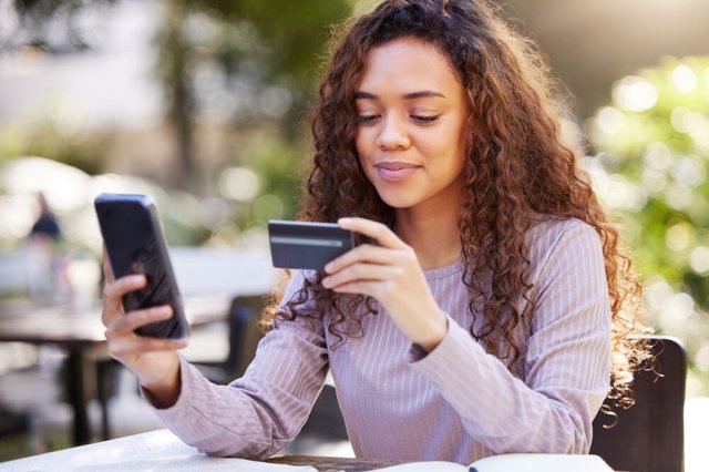 young-woman-using-a-credit-card-and-phone-1000x666.jpg