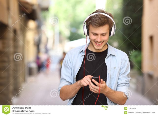 guy-walking-using-smart-phone-headphones-happy-to-listen-music-55903159.jpg