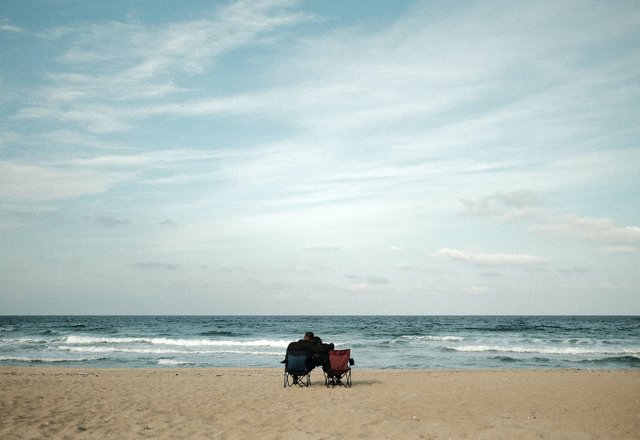 free-photo-of-couple-sitting-on-chairs-on-beach.jpeg