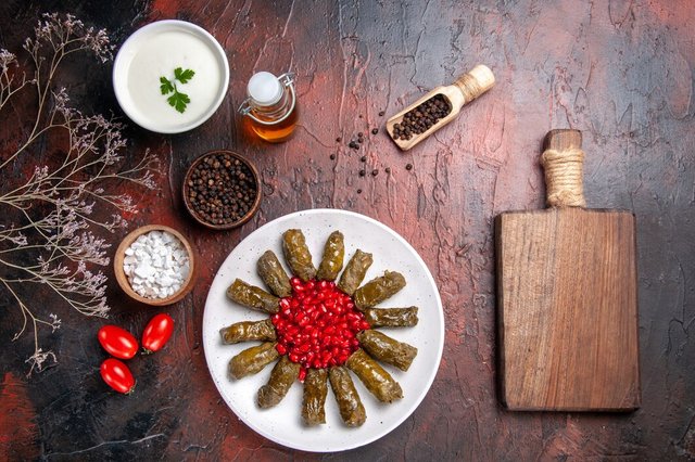 top-view-green-leaf-dolma-with-pomegranates-dark-surface_140725-75376.jpg