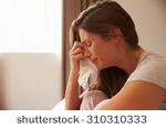 stock-photo-woman-suffering-from-depression-sitting-on-bed-and-crying-310310333.jpg