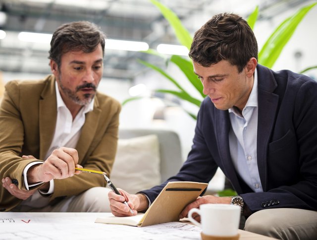 low-angle-male-coworkers-meeting-office-scaled.jpg