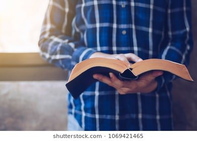 man-standing-while-reading-bible-260nw-1069421465.jpg