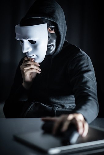 mystery-male-hoodie-hacker-wearing-black-mask-holding-white-mask-with-picture-id1044252268.jpg