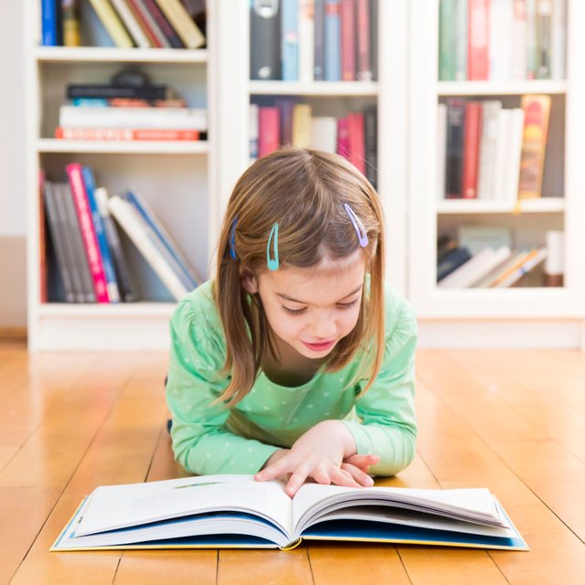 little-girl-lying-on-the-floor-reading-a-book-686736565-5a37ed66f1300a00379c8331.jpg