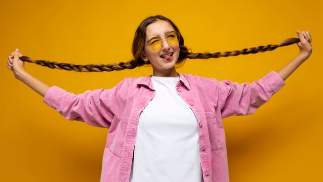 portrait-teenage-girl-holding-her-pigtails-sticking-her-tongue-out.jpg