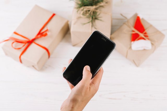 woman-holding-smartphone-gift-boxes.jpg