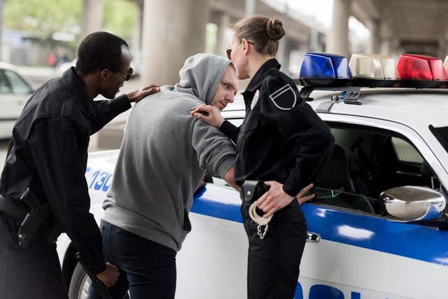 stock-photo-policeman-policewoman-arresting-young-man.jpg