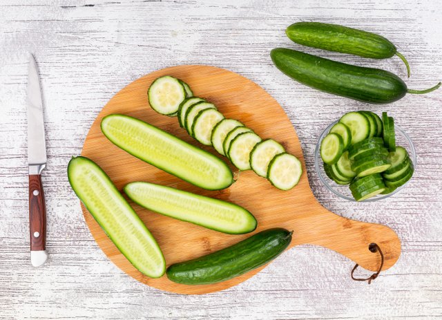 top-view-cucumber-sliced-glass-bowl-beige-cutting-board-white-wooden-horizontal.jpg