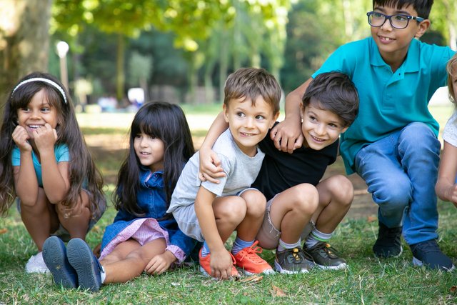 cheerful-kids-sitting-squatting-down-grass-hugging-each-other-looking-away-excitement-kids-play-entertainment-concept.jpg