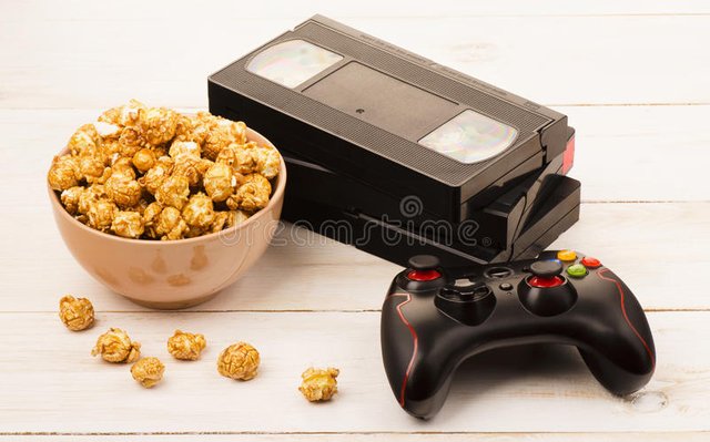 caramel-popcorn-near-videotape-gamepad-wooden-background-85918264.jpg