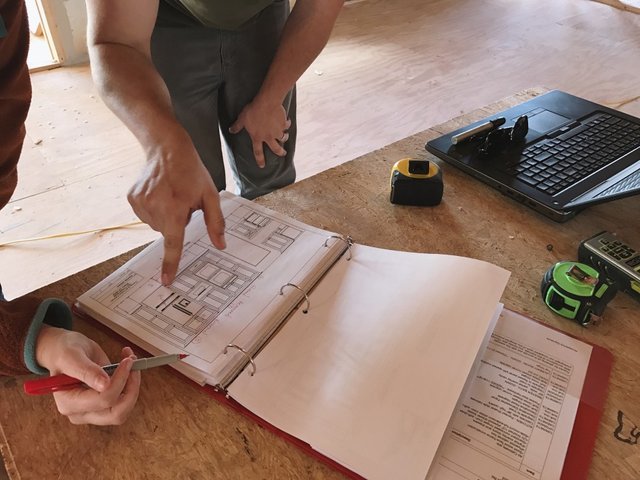 detail-photo-of-two-peoples-hands-reviewing-cabinet-elevations-for-a-kitchen-remodel_t20_WQZQO1.jpg