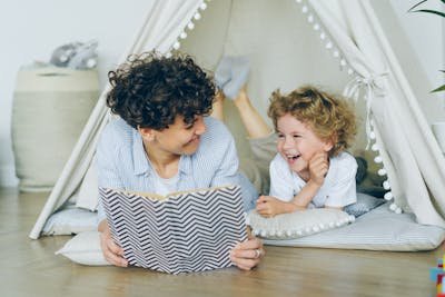 free-photo-of-mother-lying-down-with-son-in-tent-and-reading-book.jpeg