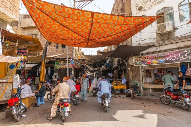 multan-inner-city-street-multan-inner-city-street-picturesque-view-rickshaw-walking-people-motorbikes-sunny-blue-sky-167709185.jpg