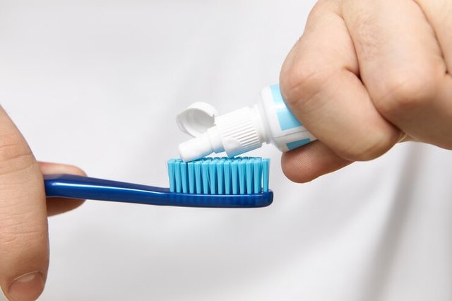 close-up-image-man-s-hands-holding-tube-squeezing-whitening-toothpaste-brush_343059-2488.jpg