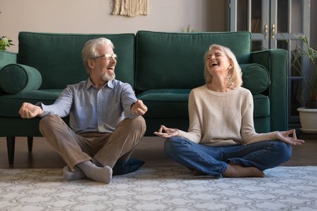 122246946-happy-mature-couple-having-fun-practicing-yoga-together-at-home-laughing-grey-haired-man-and-woman-s.jpg