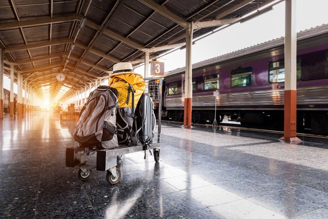 several-bags-on-trolley-near-train-in-station-1170187.jpg