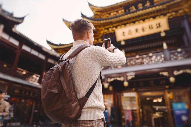 turista-maschio-che-prende-le-foto-di-una-pagoda-al-mercato-di-yuyuan-a-shanghai.jpg