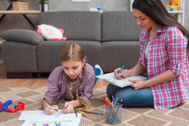 young-female-psychologist-taking-notes-while-girl-drawing-white-paper_23-2148026326.jpg