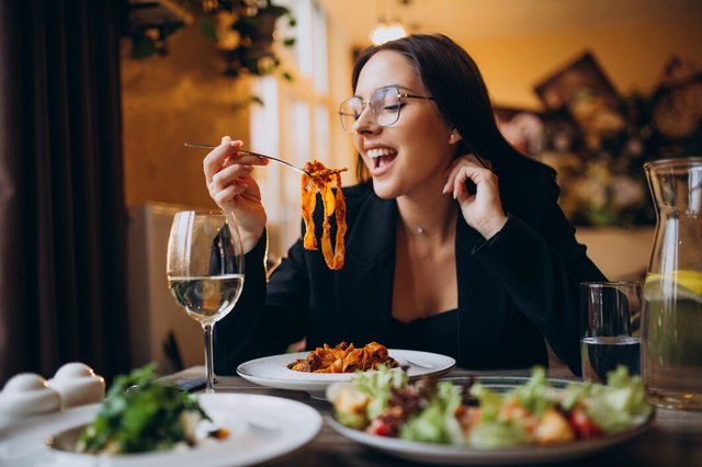 young-woman-eating-pasta-cafe_1303-25262.jpg