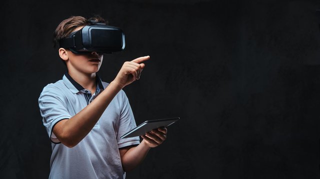 portrait-young-student-boy-dressed-white-t-shirt-using-virtual-reality-glasses-tablet-computer-isolated-dark-background.jpg