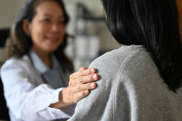 an-aged-asian-female-doctor-touching-shoulder-to-comfort-and-support-her-patient.jpg