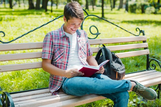 young-cheerful-man-reading-book-park_23-2147656244.jpg