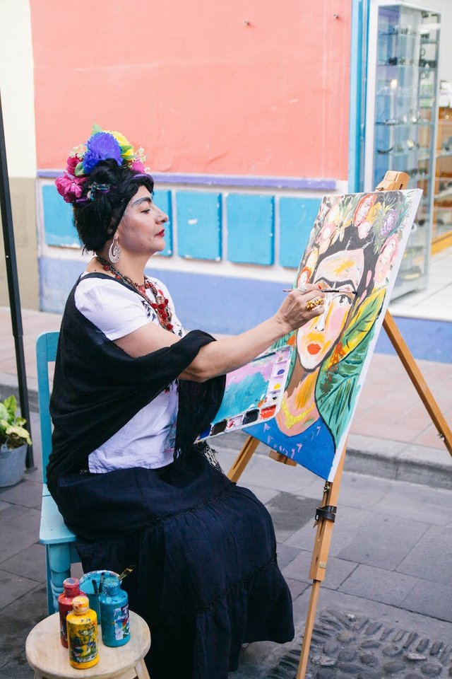 free-photo-of-woman-sitting-and-painting-in-town.jpeg