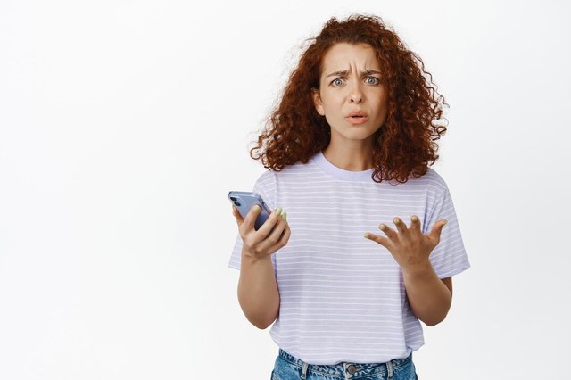 confused-redhead-girl-looking-puzzled-holding-smartphone-cant-understand-smth-phone-standing-white-background_176420-47302.jpg