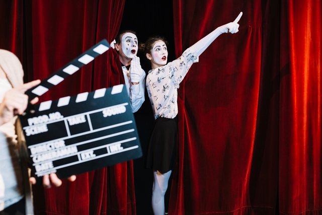 person-holding-clapper-board-front-male-mime-looking-female-mime-pointing-somewhere.jpg