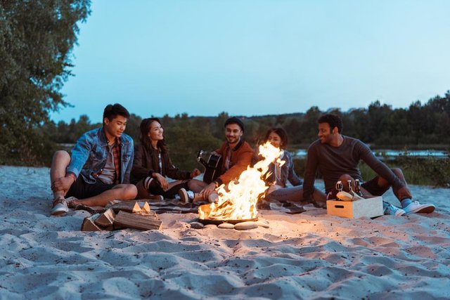 stock-photo-friends-resting-near-campfire-on.jpg