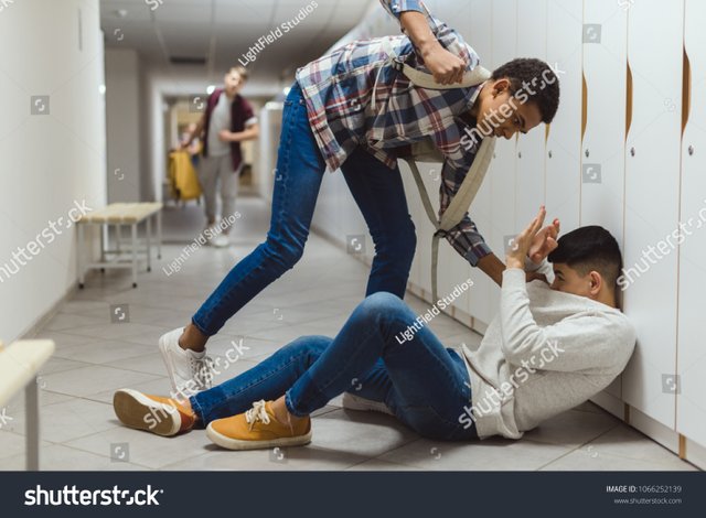 stock-photo-frightened-schoolboy-being-bullied-by-classmate-in-school-corridor-under-lockers-while-other-boy-1066252139.jpg