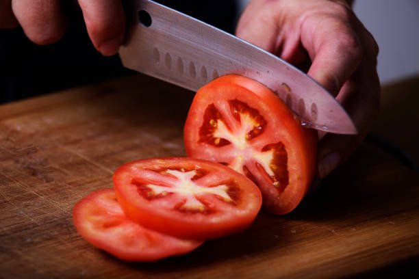 tomato-being-sliced-with-a-sharp-knife-picture-id904094088.jpg