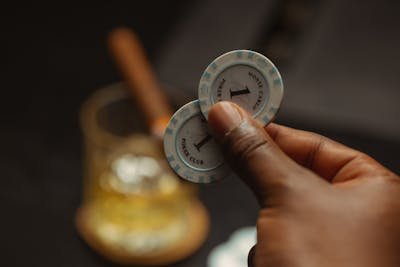 free-photo-of-close-up-of-man-holding-casino-tokens-on-the-background-of-a-glass-with-a-cocktail.jpeg