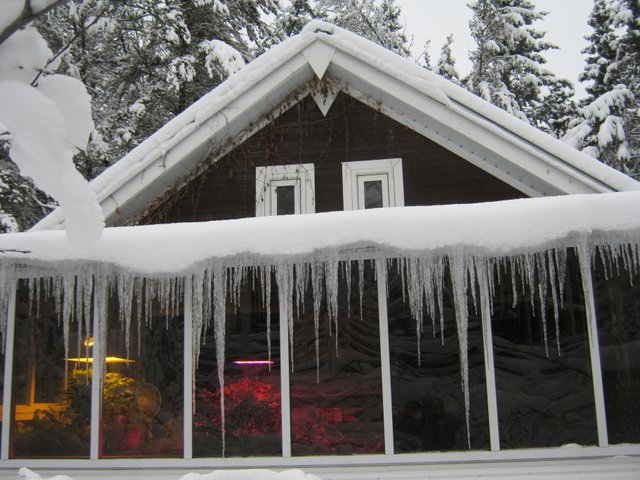 front of house with icicles on sunroom showing grow lights.JPG