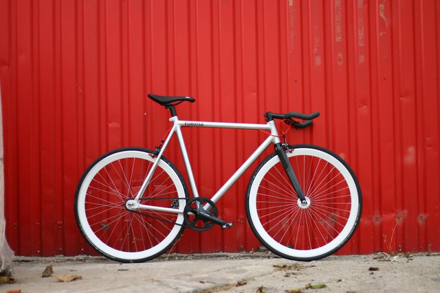 free-photo-of-a-bike-is-parked-against-a-red-wall.jpeg